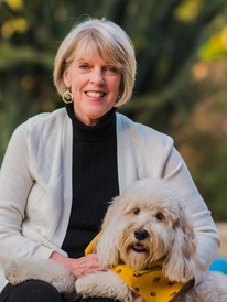 Woman smiling with dog in yellow bandana.